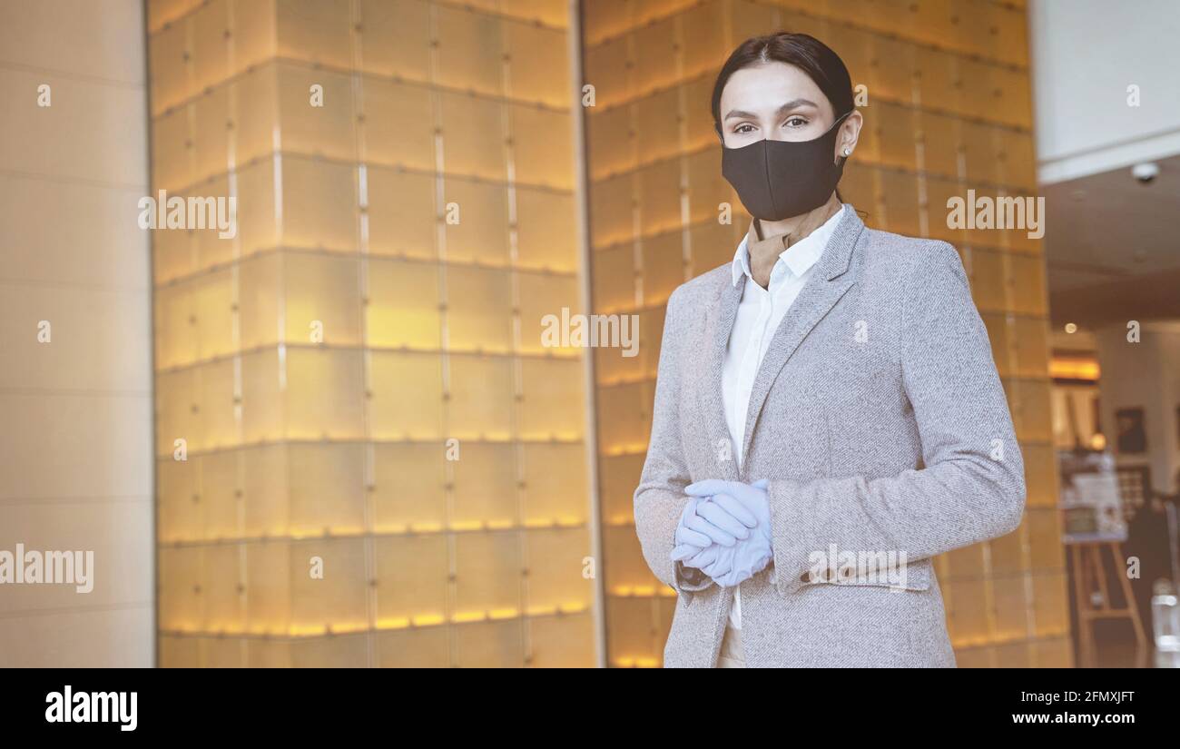 Business center receptionist following the pandemic safety precautions Stock Photo