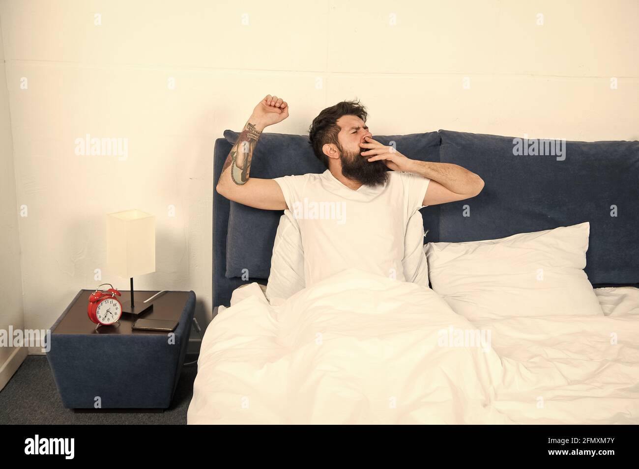 Bed is so comfortable in morning. Hipster give long yawns in bed. Bearded man stay in bed after wakeup. Bed time routine. Bedroom. Getting the rest Stock Photo