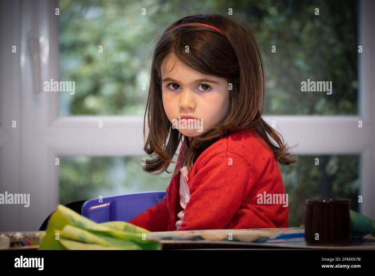 Portrait d'une petite fille boudeuse de quatre ans. / Portrait of a sulky four-year-old girl. Stock Photo