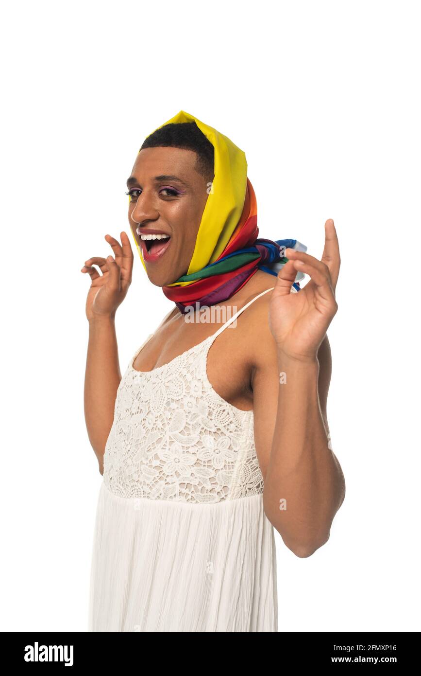 excited african american transvestite man in dress and rainbow colors head kerchief isolated on white Stock Photo