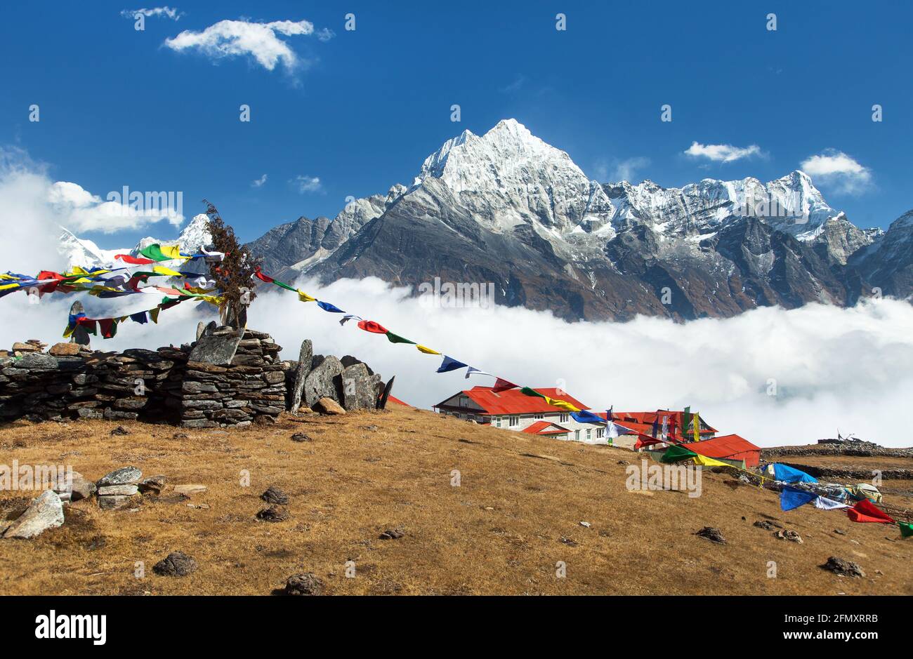 View of mount Thamserku, Kongde village and prayer flags, Khumbu valley, Solukhumbu, Nepal Himalayas mountains Stock Photo