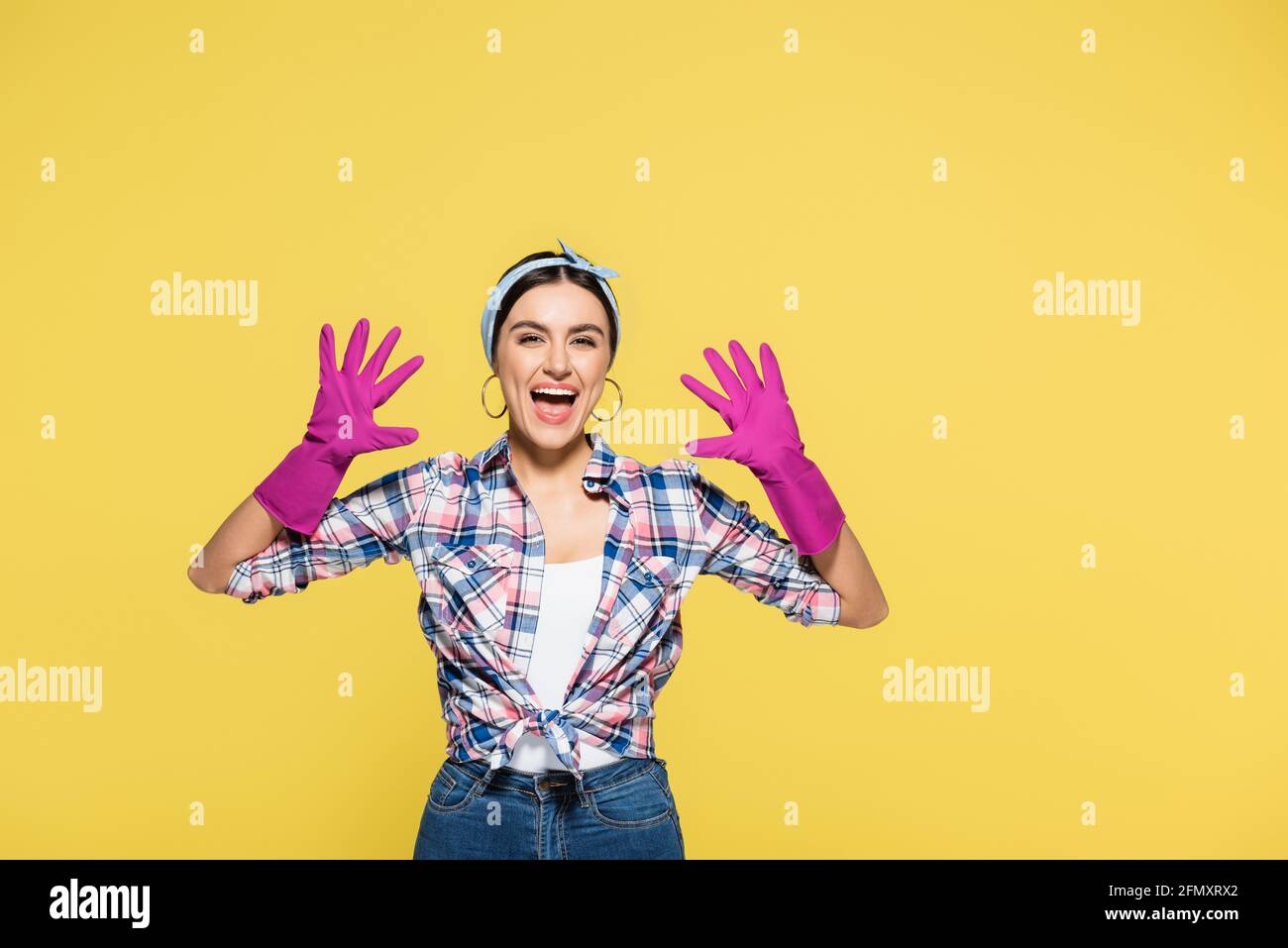 Cheerful woman in rubber gloves isolated on yellow Stock Photo - Alamy