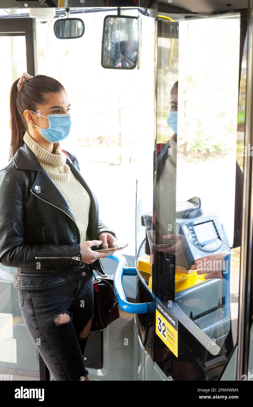 Woman using mobile payment on bus Stock Photo