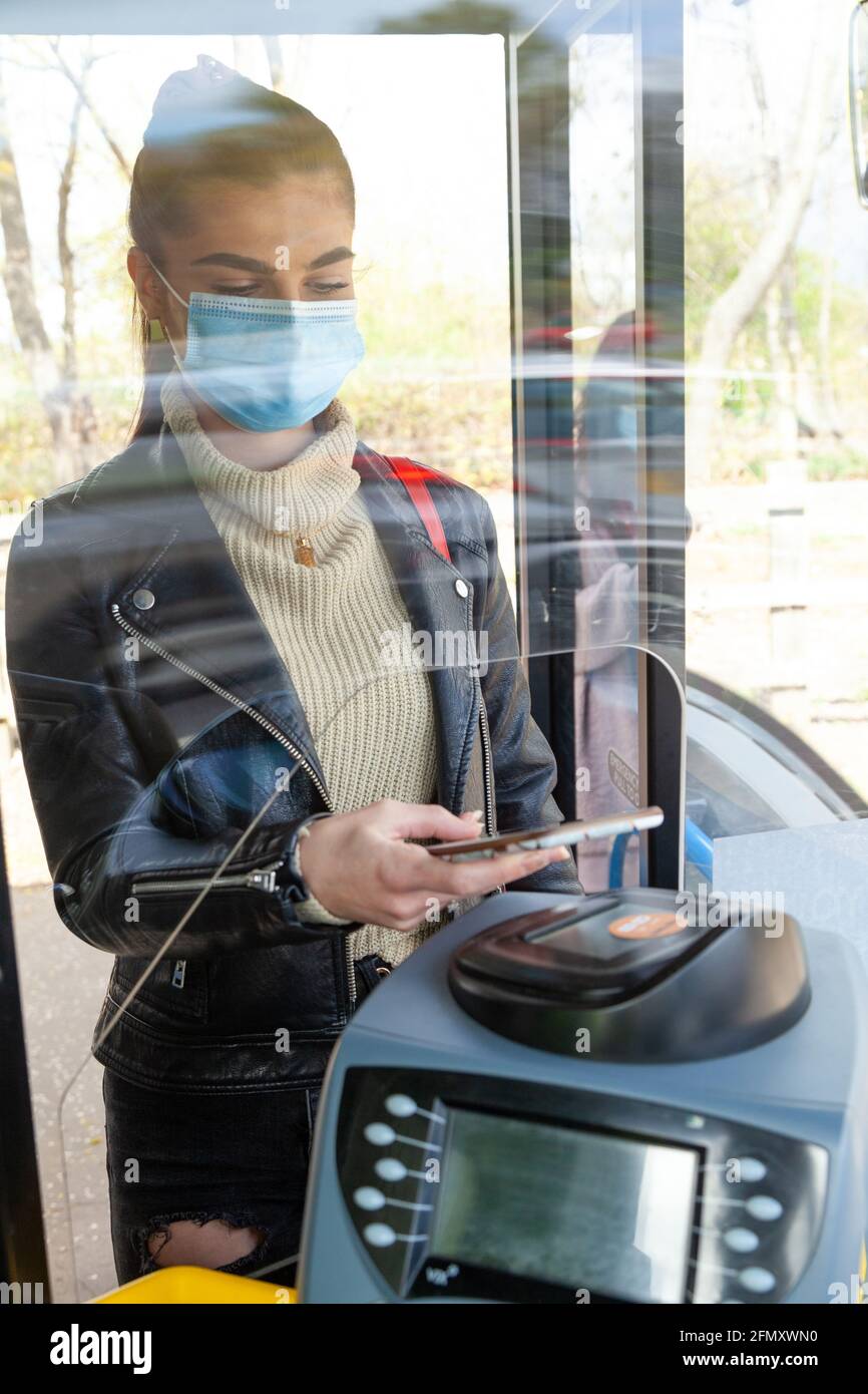 Woman using mobile payment on bus Stock Photo