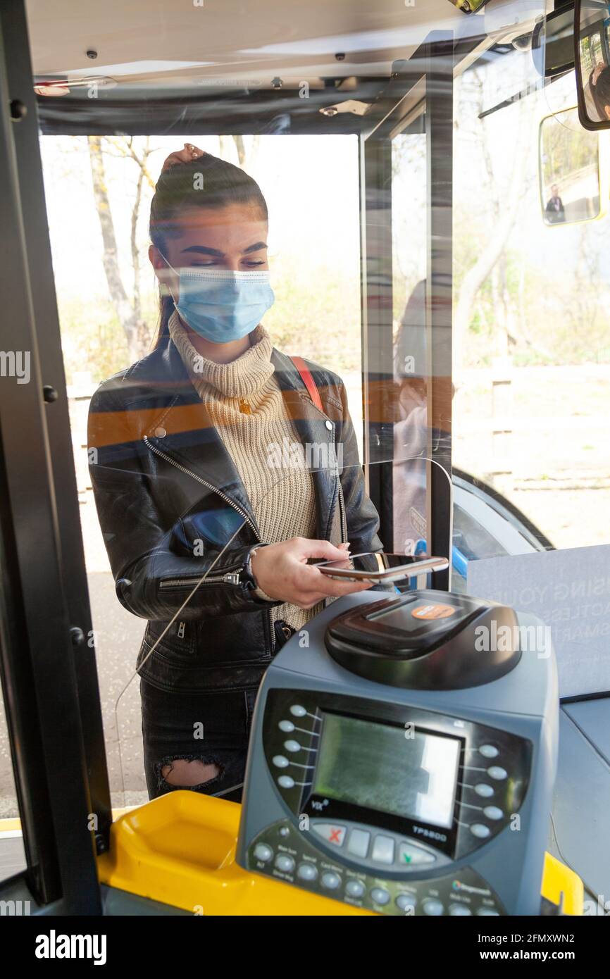 Woman using mobile payment on bus Stock Photo