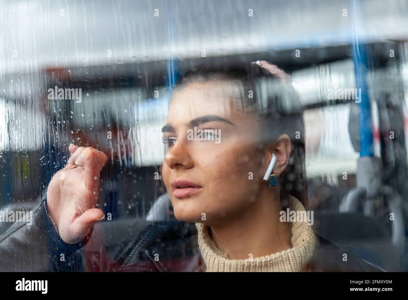 Girl staring out of rainy window on a bus Stock Photo