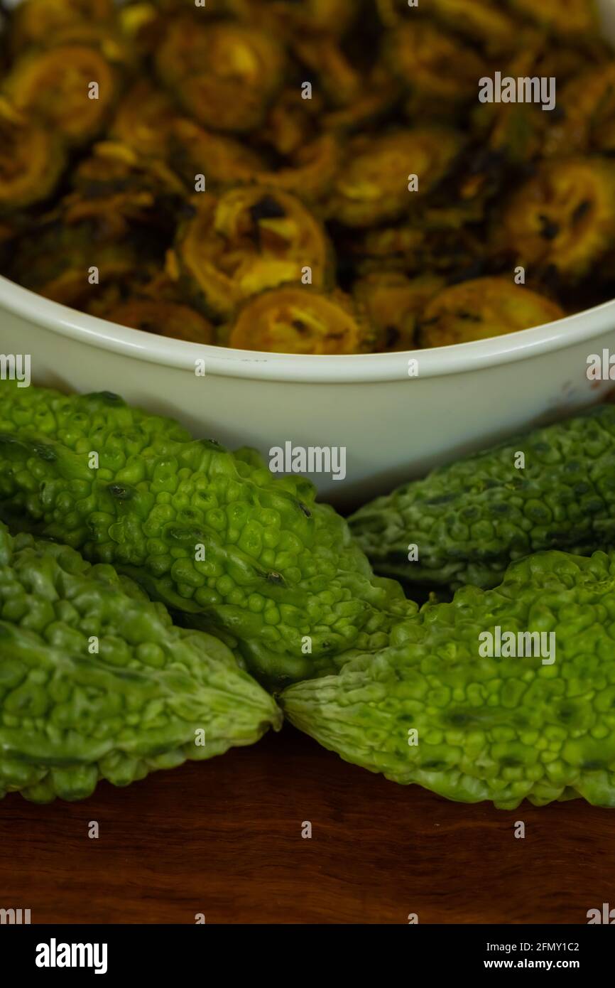 Cooked bitter gourd and raw bitter gourd kept alongside each other