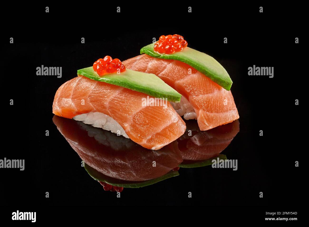 Two nigiri sushi with salmon, avocado, caviar on black background Stock Photo