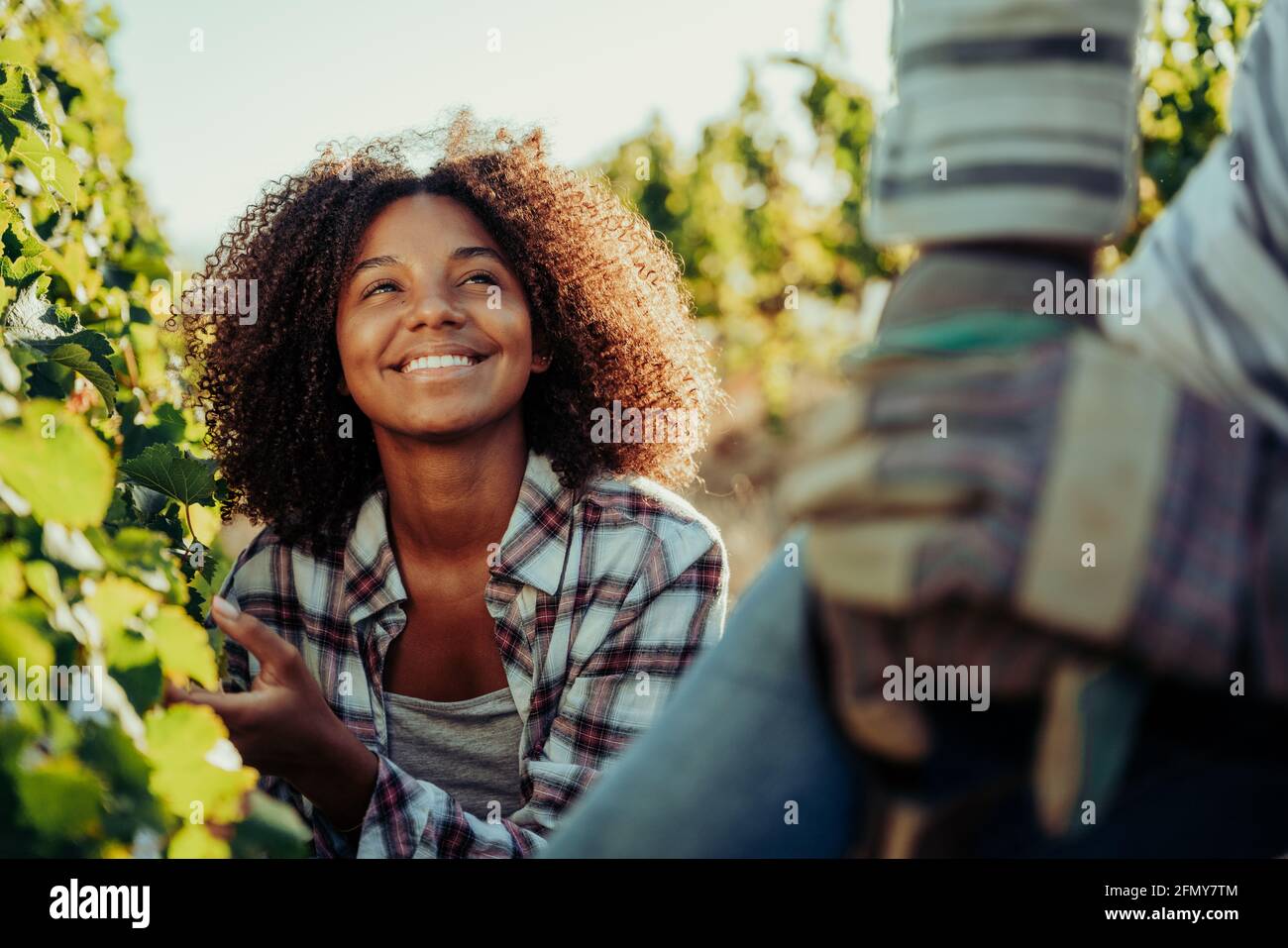 Mixed race female farmer smiling at male colleague while enjoying working on beautiful farm Stock Photo