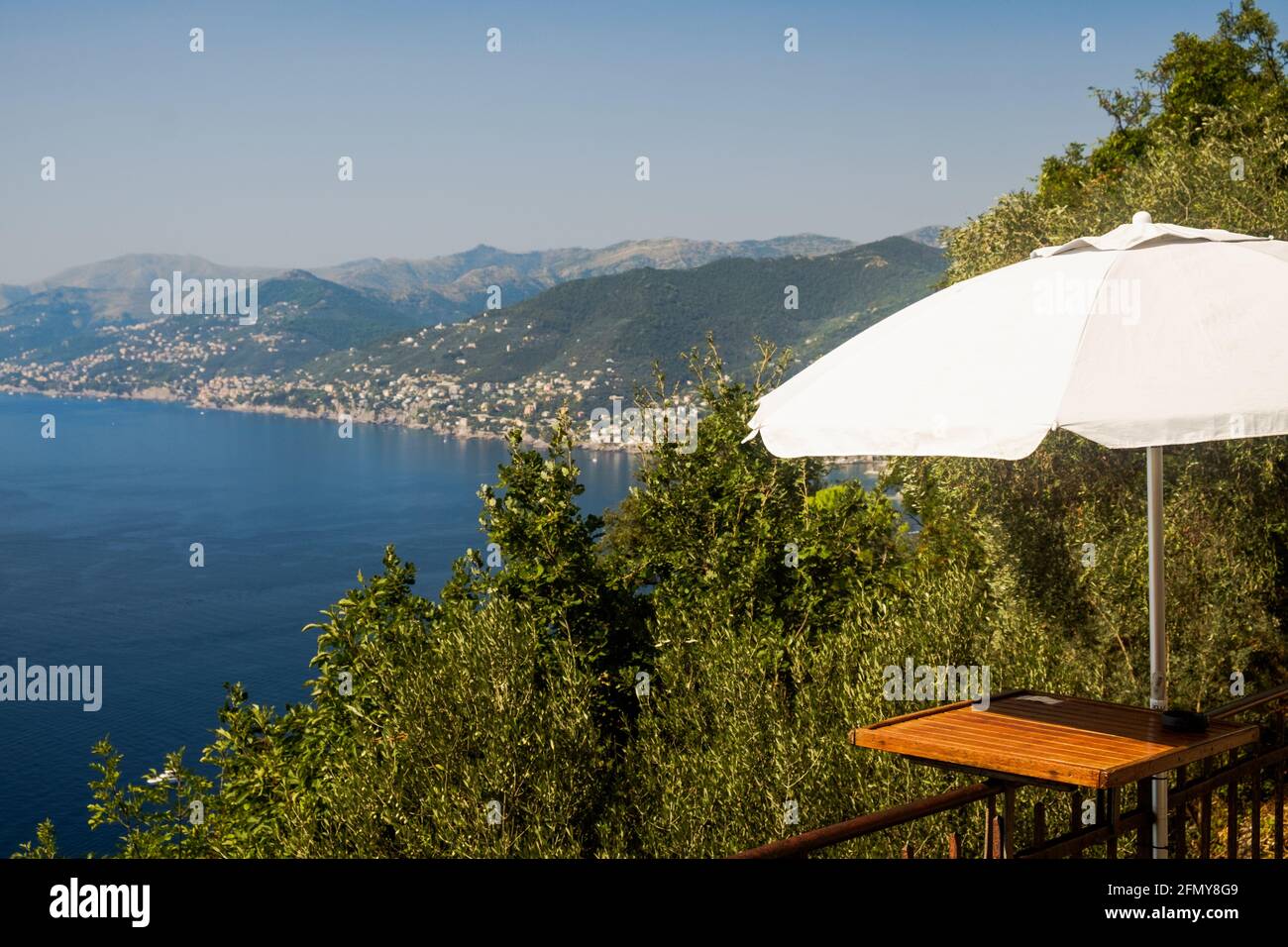 The path from Punta Chiappa to Camogli brings you along a bar with outdoor tables and a stunning panorama of the Ligurian coastline. Stock Photo
