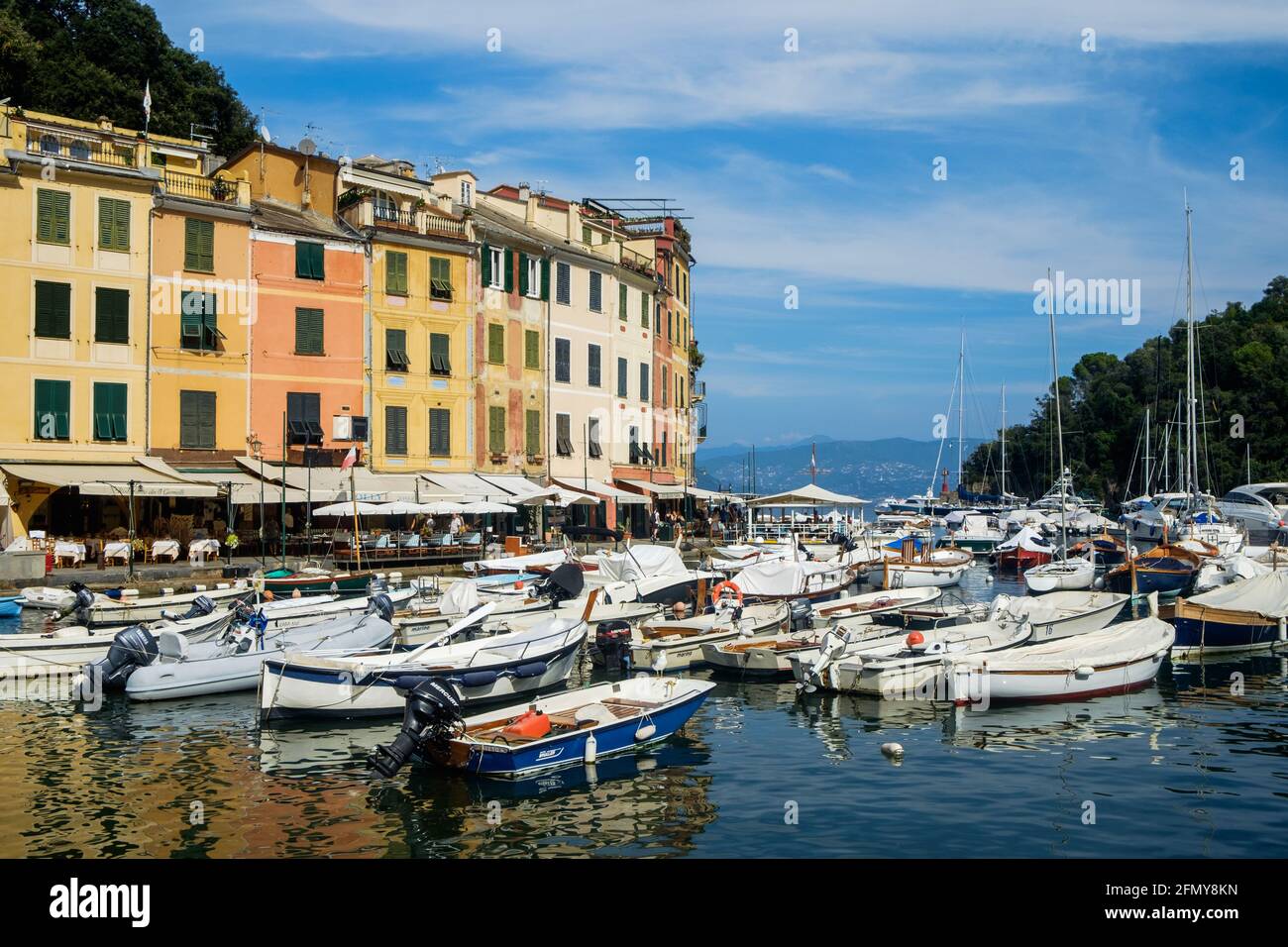 Colorful houses border the small harbour of Portofino. Recreational boats lie on the water. Stock Photo