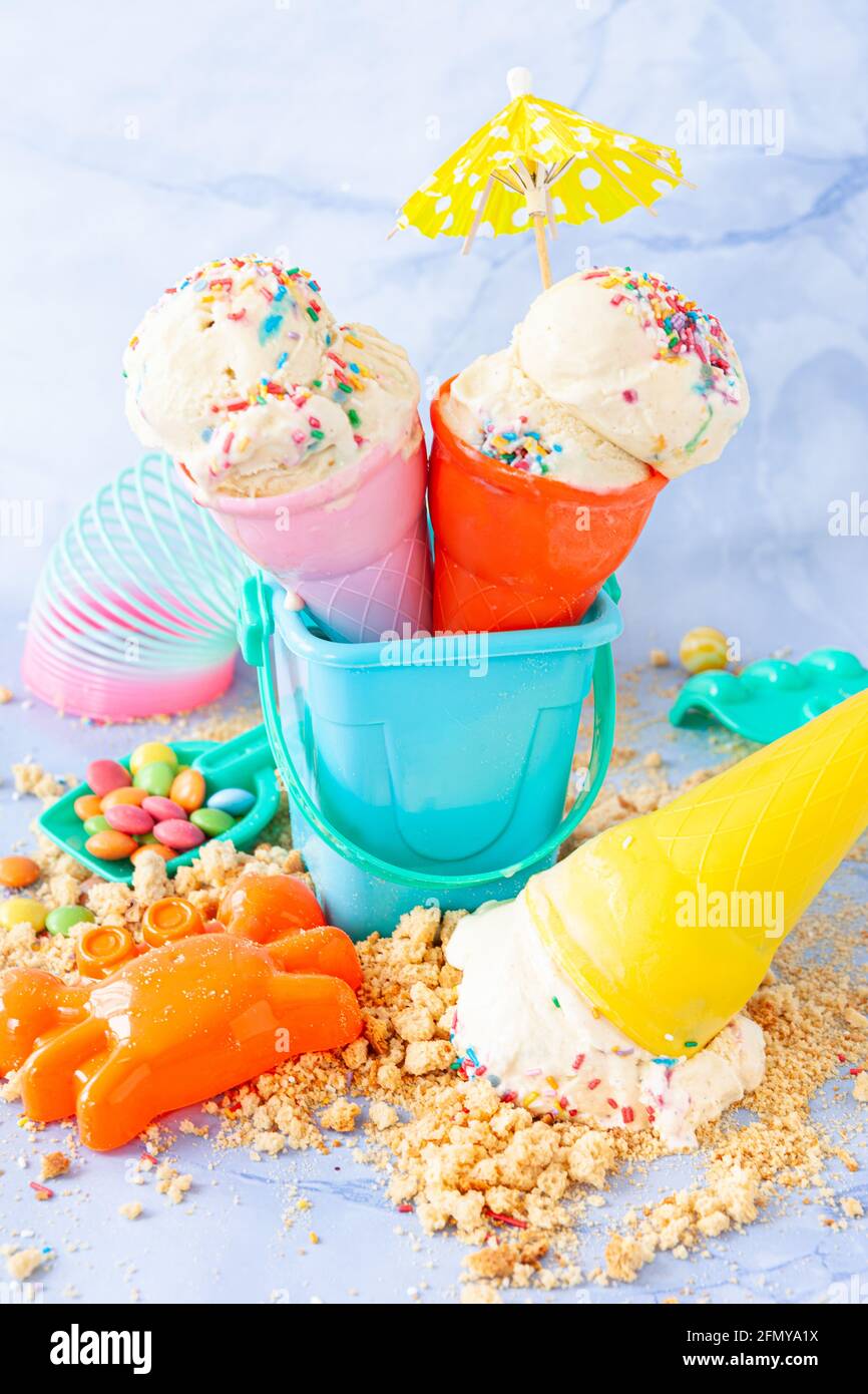 Vanilla ice cream with colorful sugar sprinkles with colorful beach toys  Stock Photo - Alamy
