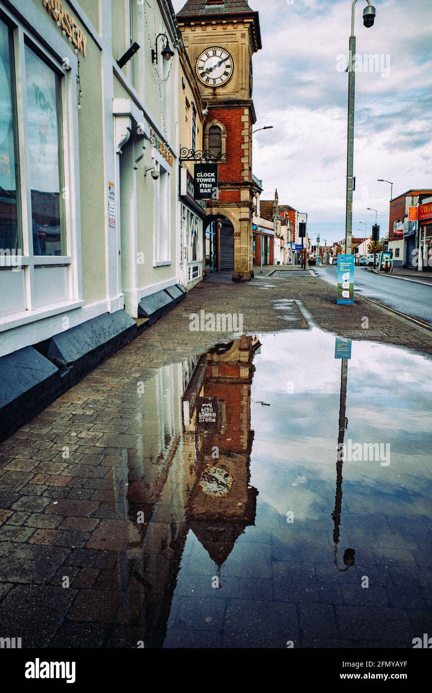 Clock tower reflecting in puddle of water (May21). Kingswood, Bristol