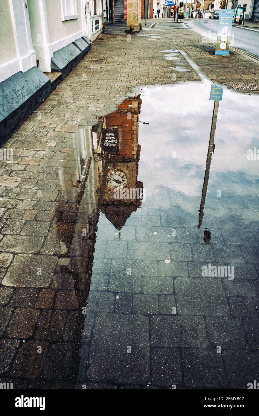 Clock tower reflecting in puddle of water (May21). Kingswood, Bristol