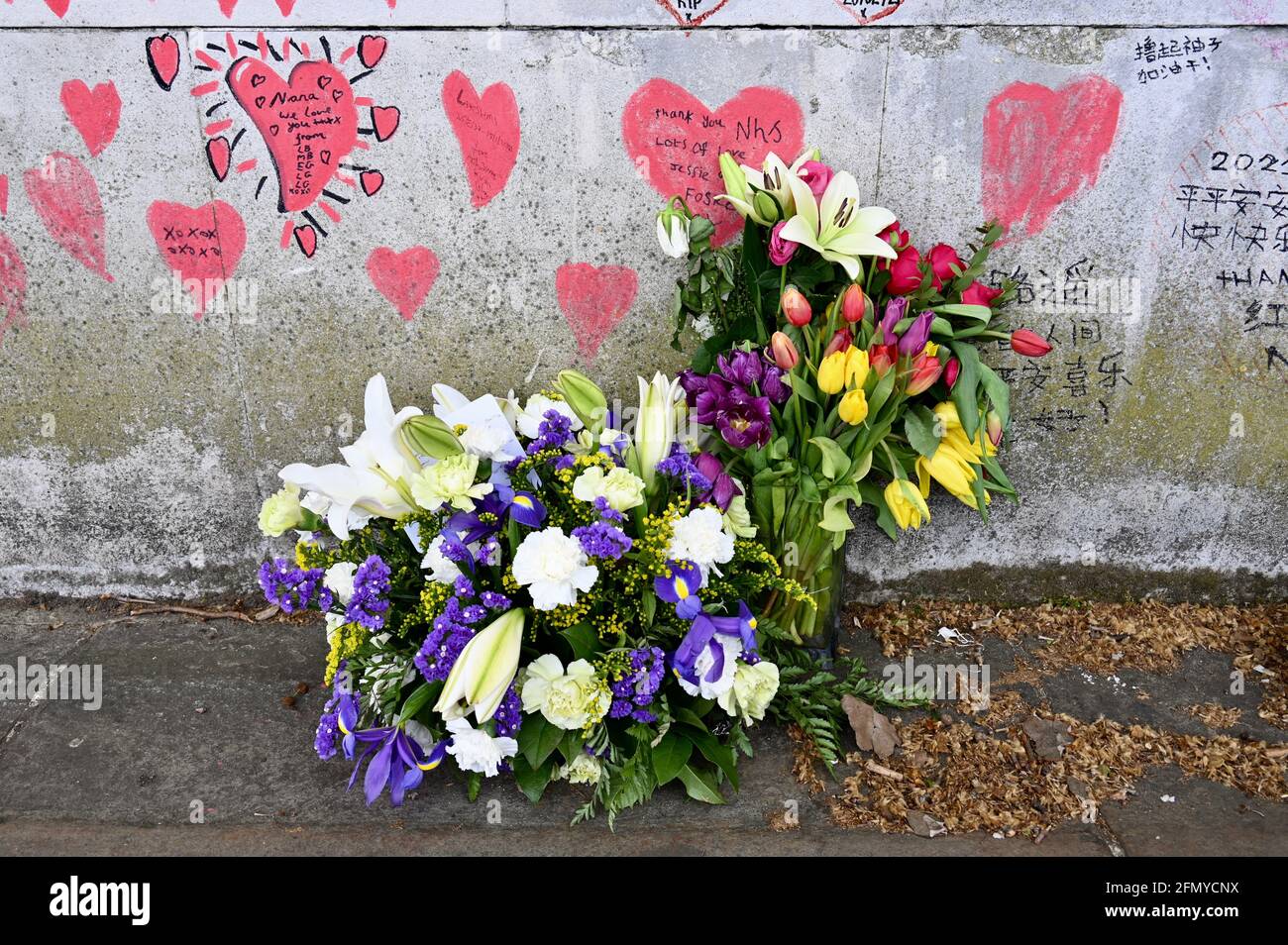 Floral bouquets, National COVID Memorial Wall, a public mural to commemorate victims of the COVID-19 Pandemic.South Bank walkway, Westminster, London. UK Stock Photo