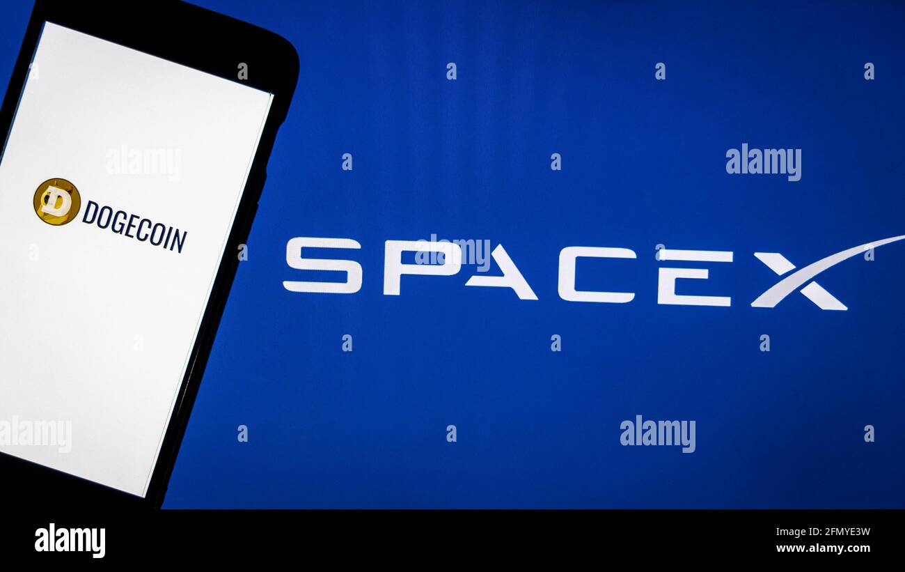 Dogecoin logo on a smartphone against SpaceX logo in the background. SpaceX accepts Dogecoin as payment to launch ‘DOG Stock Photo