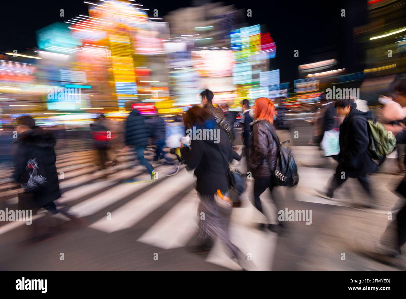 Tokyo, Japan - January 8, 2016:  Motion blur of people at a street crossing in the bustling district of Akihabara Electric Town. Stock Photo