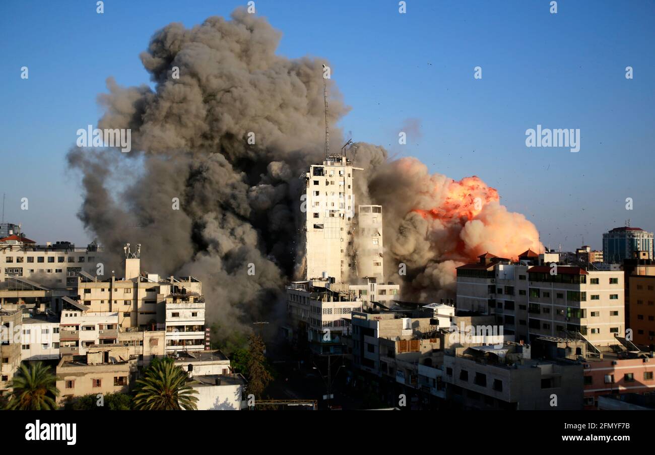 Gaza, Palestine. 12th May, 2021. Smoke and flames rise from a tower building destroyed by Israeli air strikes amid a flare-up of Israeli-Palestinian violence in Gaza CityIsrael carried out hundreds of air strikes in Gaza on Wednesday and Palestinian militants fired multiple rocket barrages at tel aviv and the southern city of Beersheba in the region's most intense hostilities in years. Credit: SOPA Images Limited/Alamy Live News Stock Photo