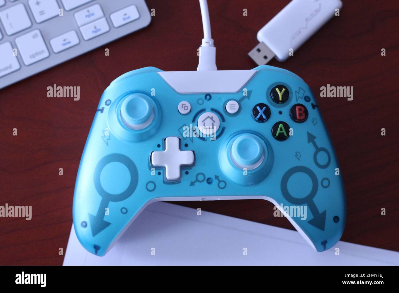 In this photo illustration, a generic controller for Microsoft Xbox 360  game system and its USB dongle are displayed on a table with various  accessories in the background Stock Photo - Alamy