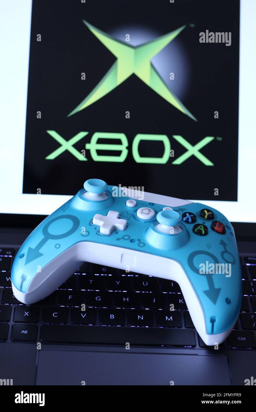 In this photo illustration, a generic controller for Microsoft Xbox 360  game system displayed on the keyboard of a laptop with a XBOX logo in the  background. (Photo by Thibaud Mougin /
