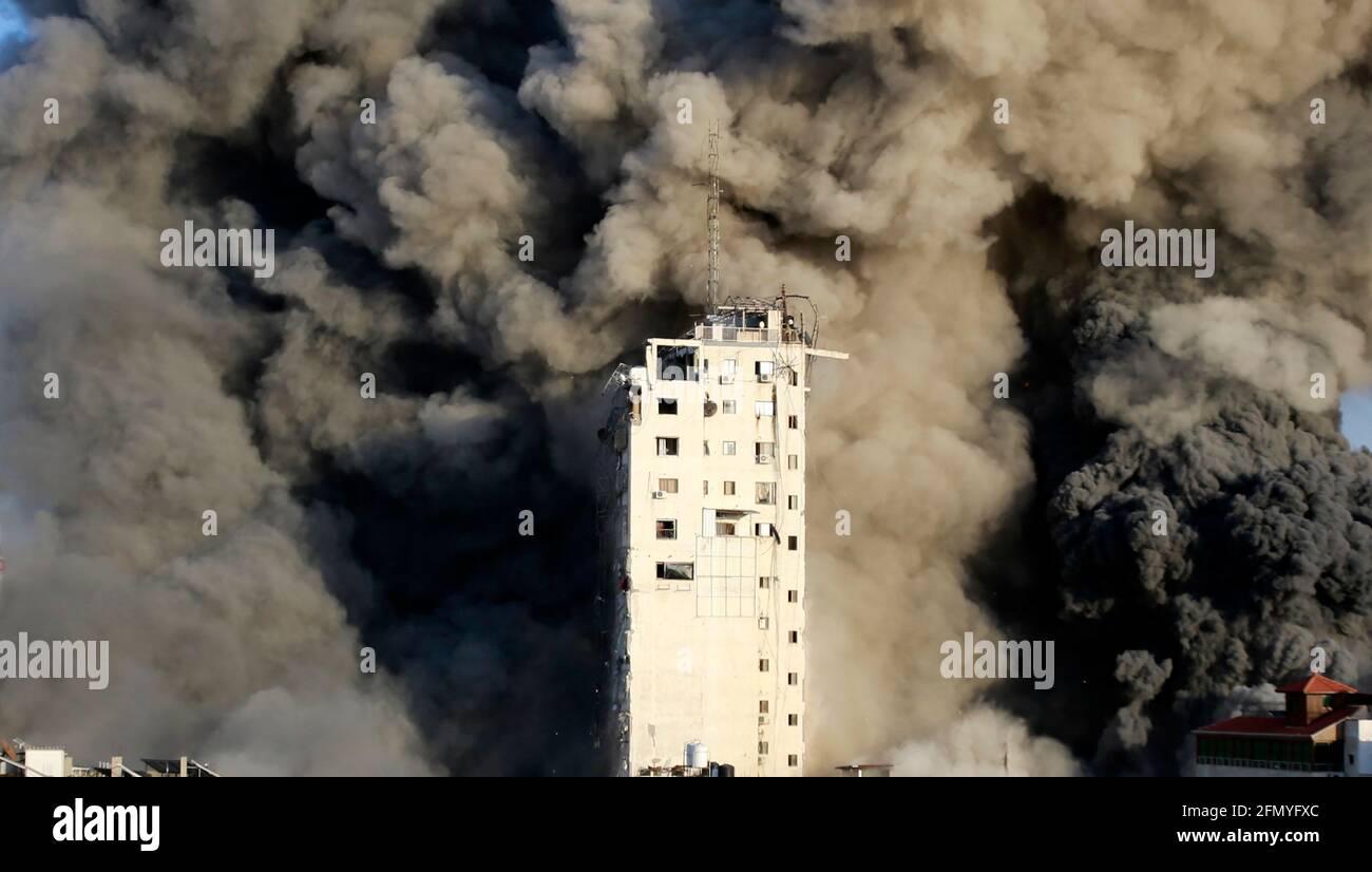 Gaza, Palestine. 12th May, 2021. Smoke rises from a tower building destroyed by Israeli air strikes amid a flare-up of Israeli-Palestinian violence in Gaza CityIsrael carried out hundreds of air strikes in Gaza on Wednesday and Palestinian militants fired multiple rocket barrages at tel aviv and the southern city of Beersheba in the region's most intense hostilities in years. (Photo by Ahmed Zakot/SOPA Images/Sipa USA) Credit: Sipa USA/Alamy Live News Stock Photo