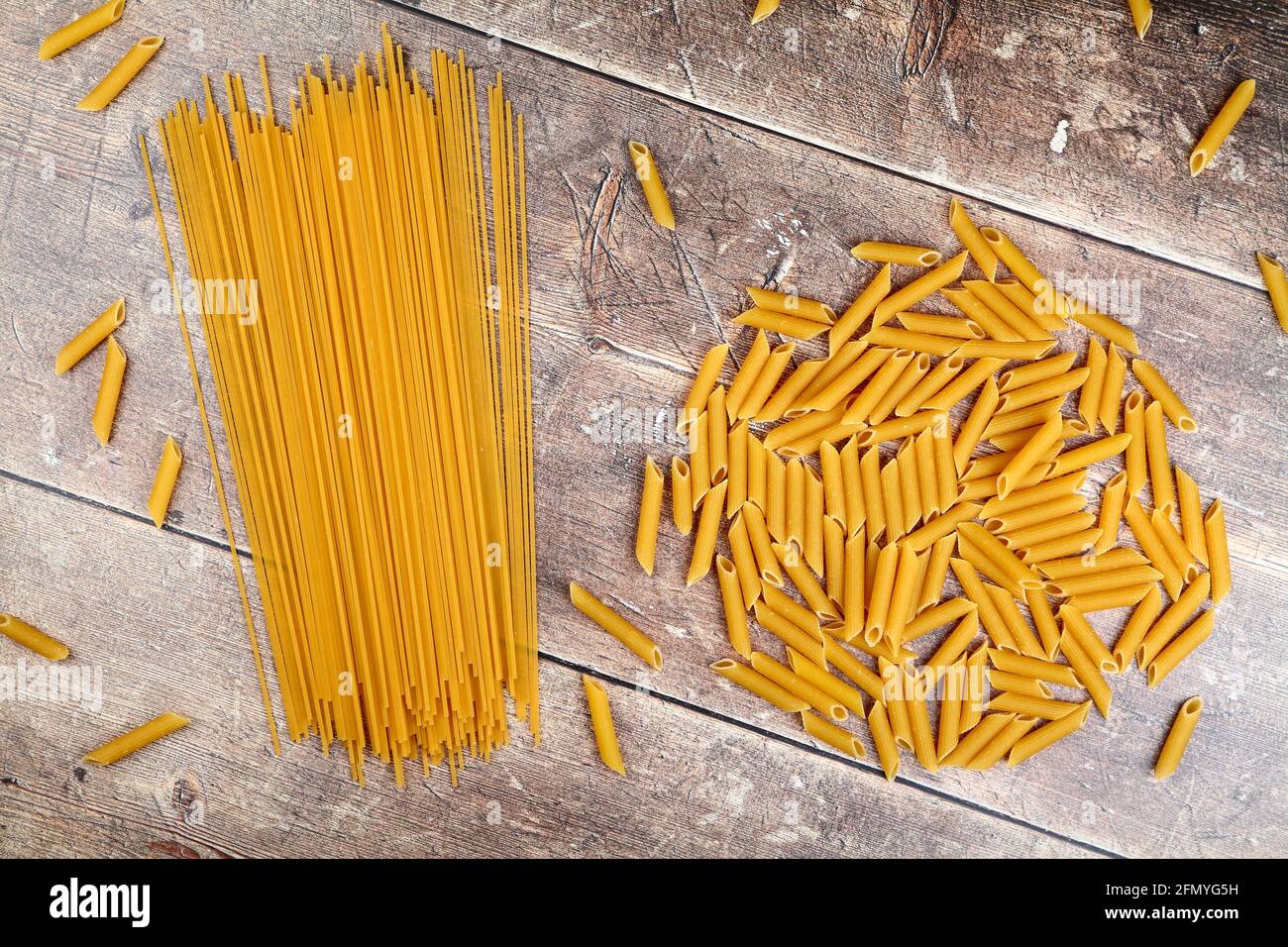Flat lay overhead view of pasta shapes and spaghetti on a wooden table top Stock Photo