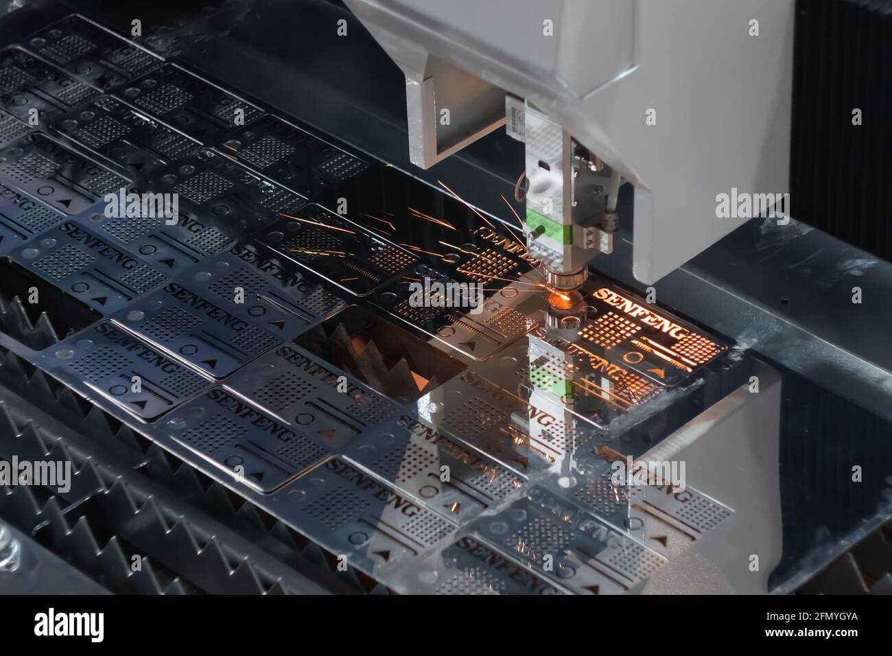 Laser cutting machine working with sheet metal with sparks Stock Photo