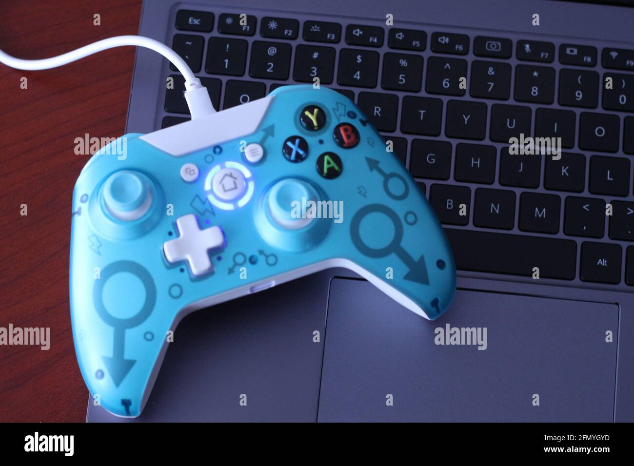 China. 30th Apr, 2021. In this photo illustration, a generic wired  controller for Microsoft Xbox 360 game system is displayed on the keyboard  of a laptop. Credit: Thibaud Mougin/SOPA Images/ZUMA Wire/Alamy Live