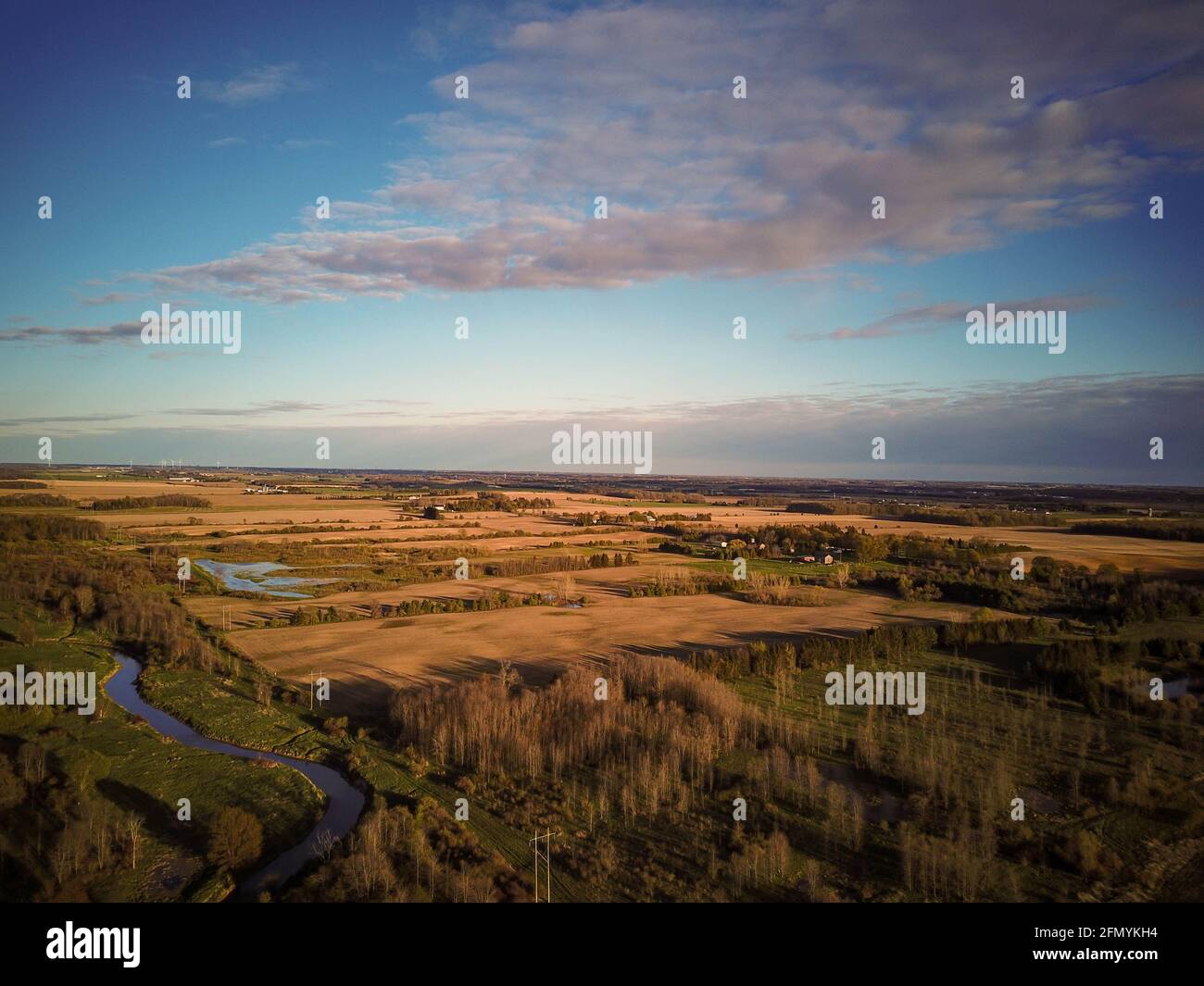 Aerial view of a yellow wheat rye and green corn farm fields going into ...