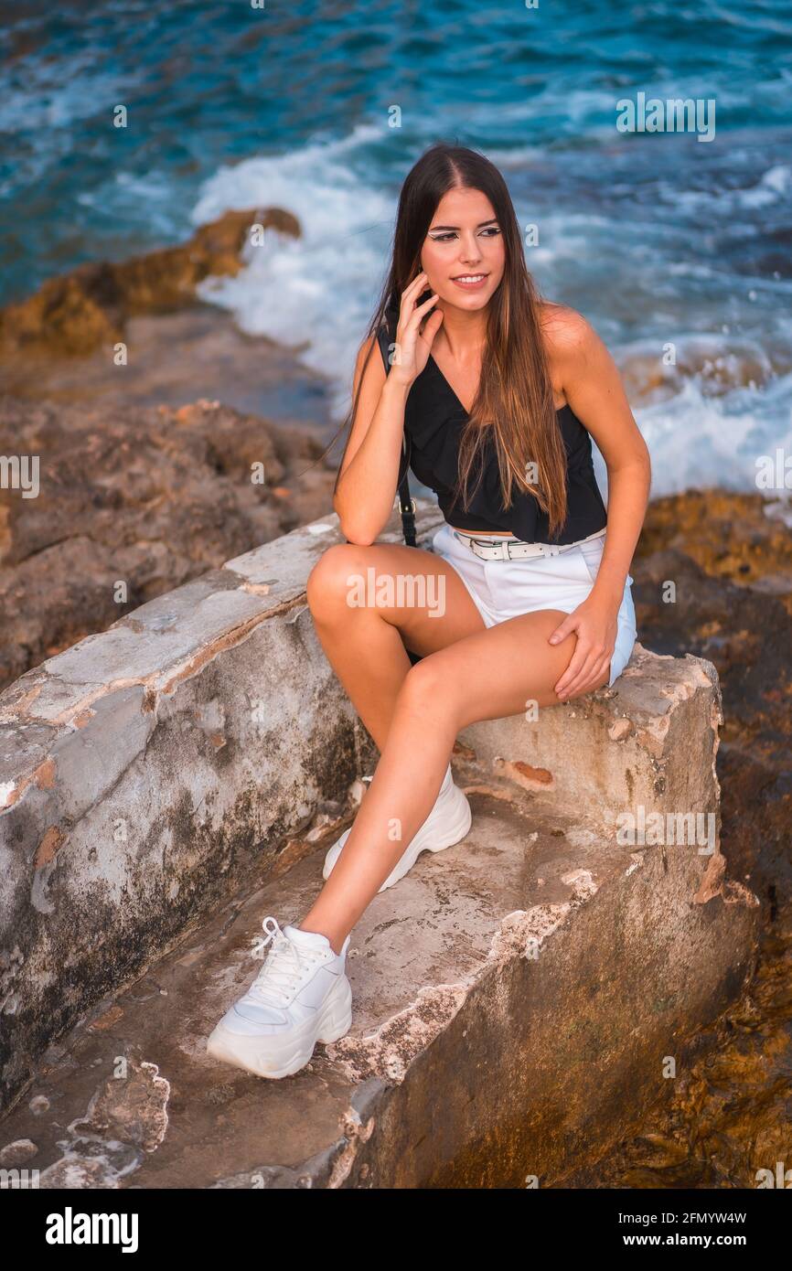 Portrait of sexy young Caucasian woman sitting on rocky coast with breasts  exposed, Stock Photo, Picture And Royalty Free Image. Pic. LPX-U21736378