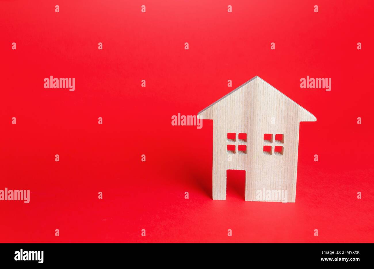 Wooden house on red background. Buying and selling real estate. Housing, realtor services. Renovation and home improvement. Building maintenance. Shor Stock Photo