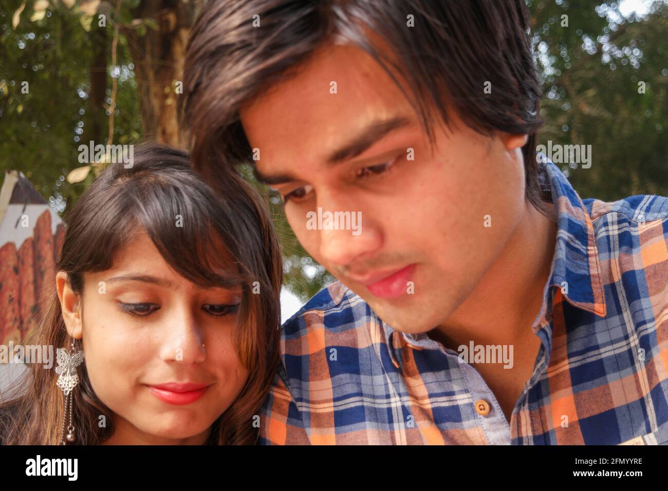 Beautiful Indian couple sit together at the park Stock Photo - Alamy