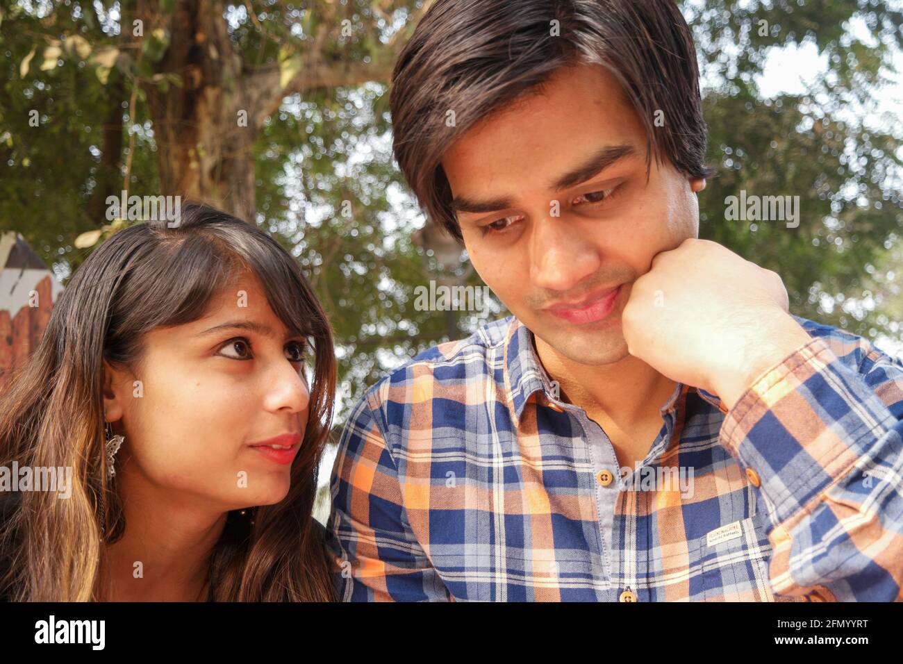 Beautiful Indian couple sit together at the park Stock Photo - Alamy