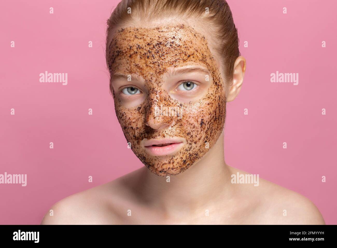 Facial skin scrub Coffee grounds mask on the face of a beautiful young