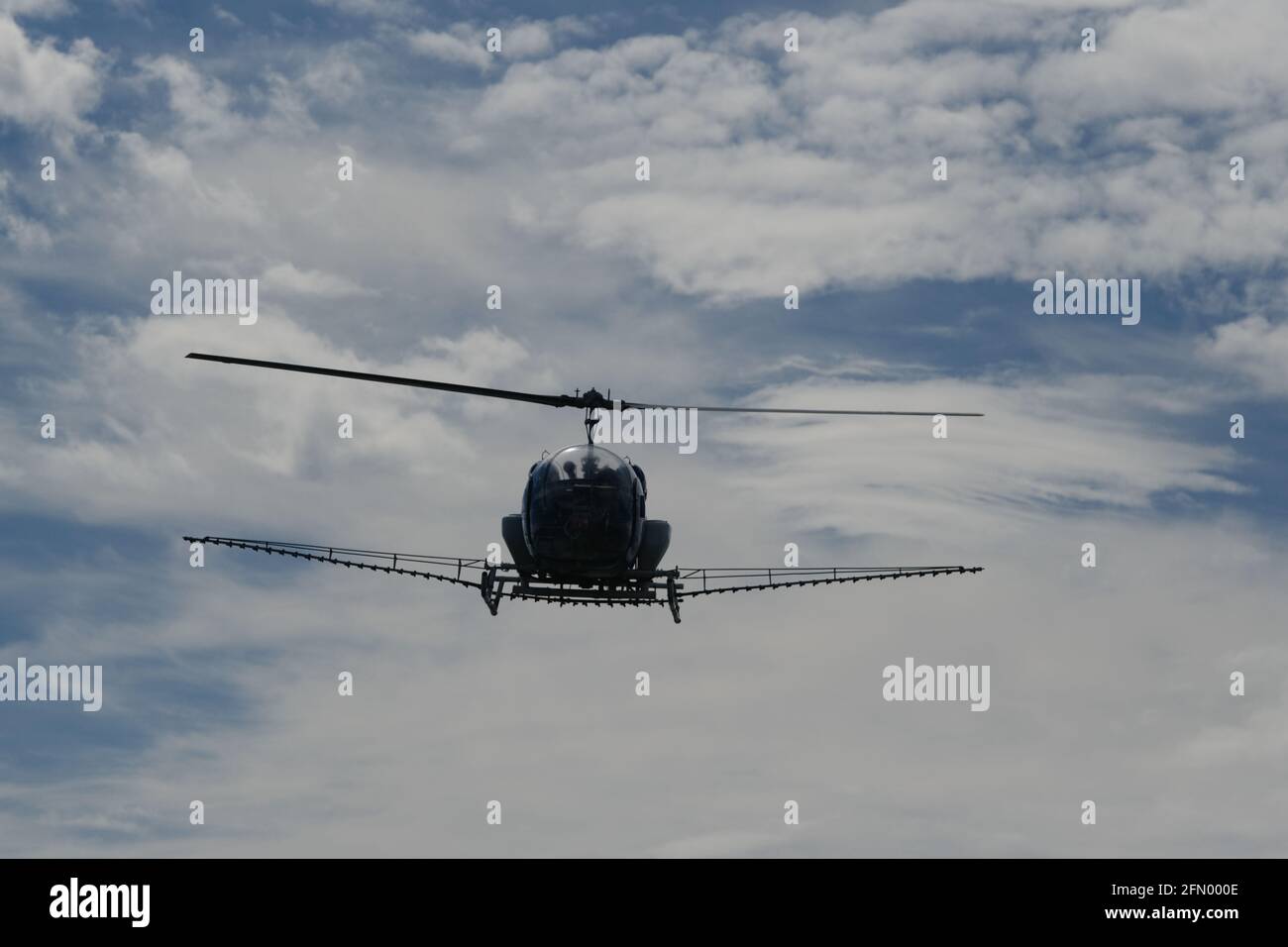 Helicopter spraying mosquito repellent in over salt lakes in Palavas