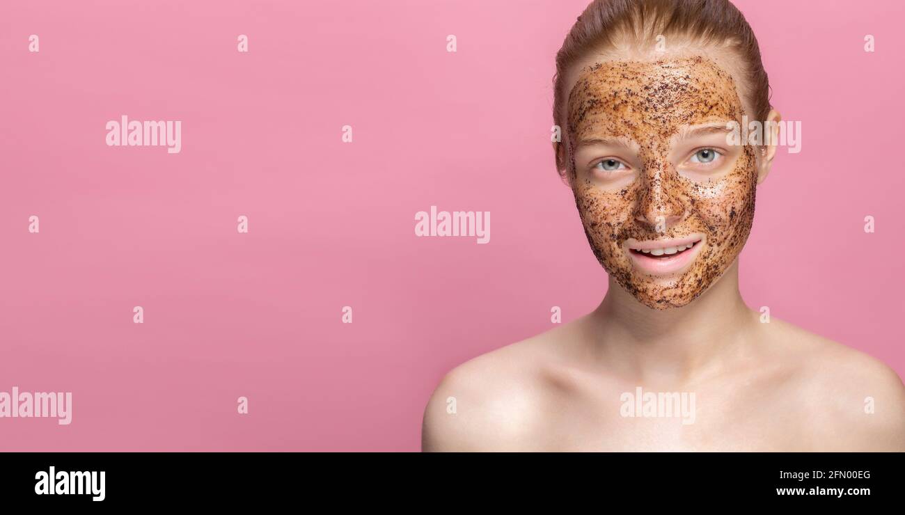 Facial skin scrub Coffee grounds mask on the face of a beautiful young