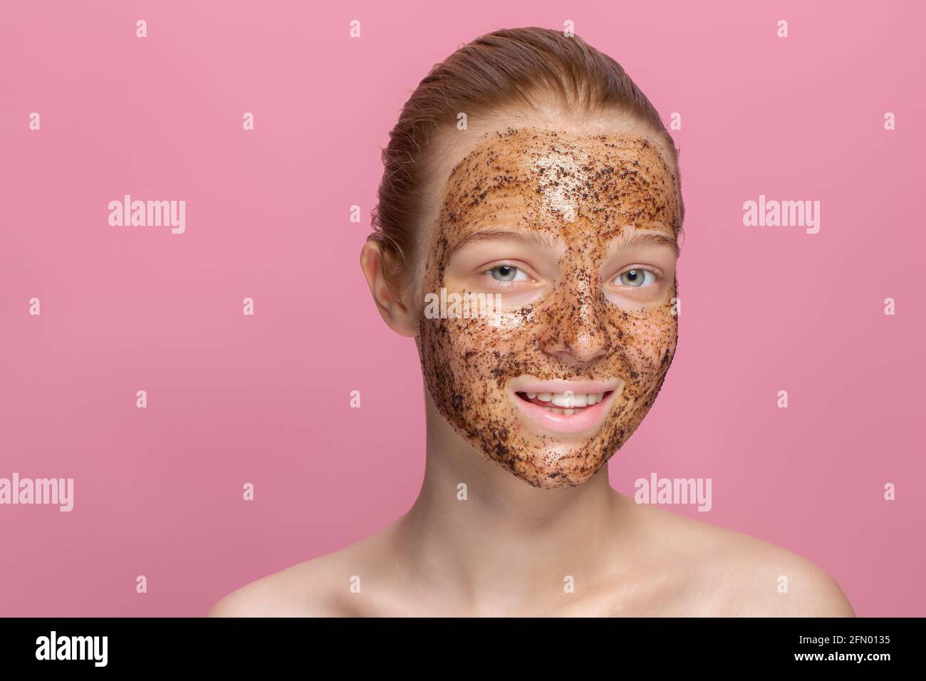 Facial skin scrub Coffee grounds mask on the face of a beautiful young
