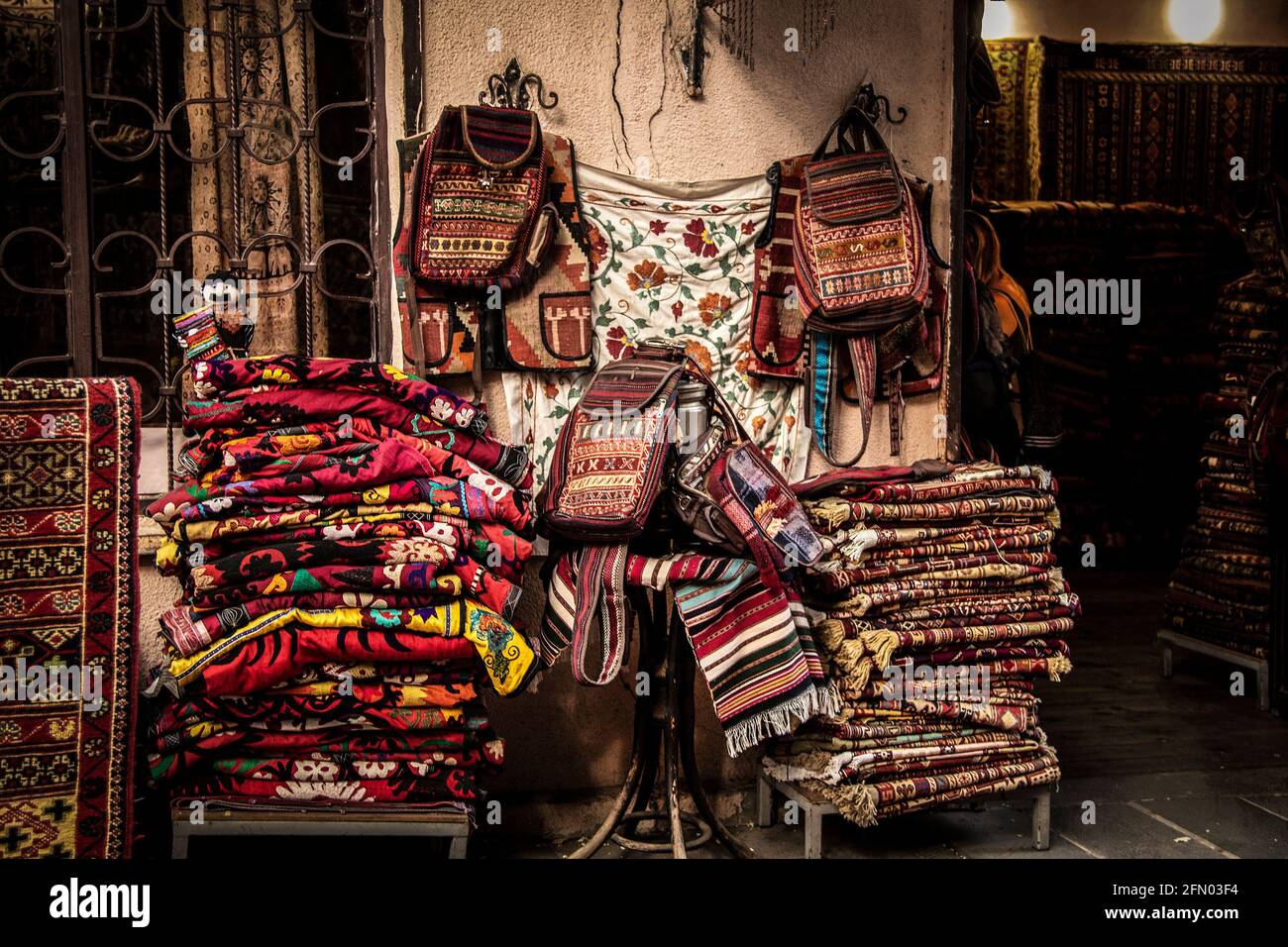 A pile of Embroidery Suzani Textile tapestries and backpacks and rugs outside a store in Tbilisi Stock Photo