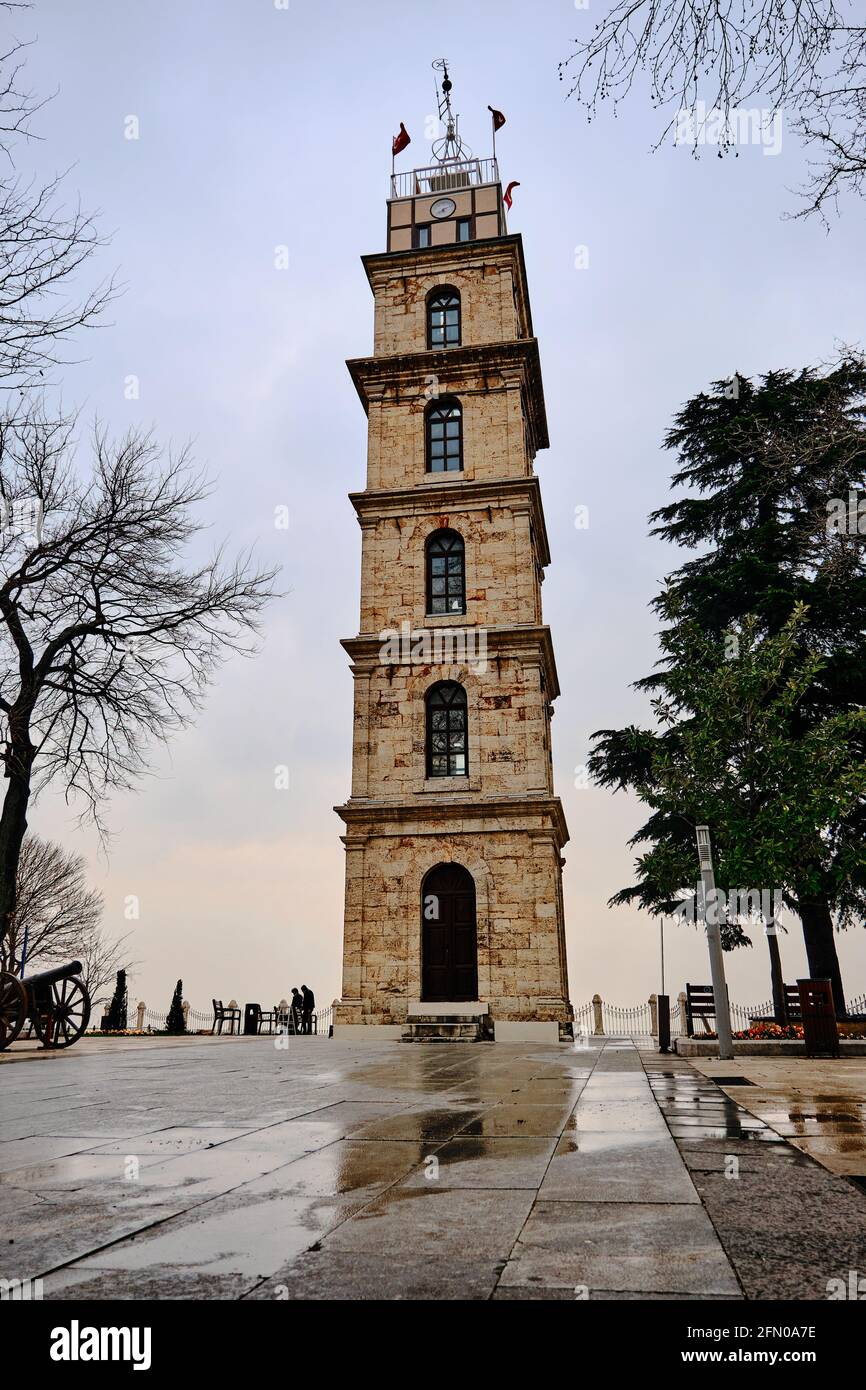 Bursa Tophane district with old watch tower established by ottoman empire. Old and ancient towers facade with huge clouds background. Stock Photo