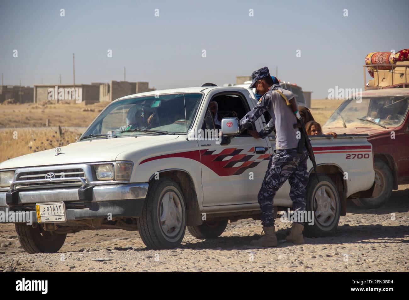 Mosul, Iraq. 9th Jun 2017 An Iraqi Federal Police officer questions a driver at a checkpoint near Mosul, Iraq. Stock Photo