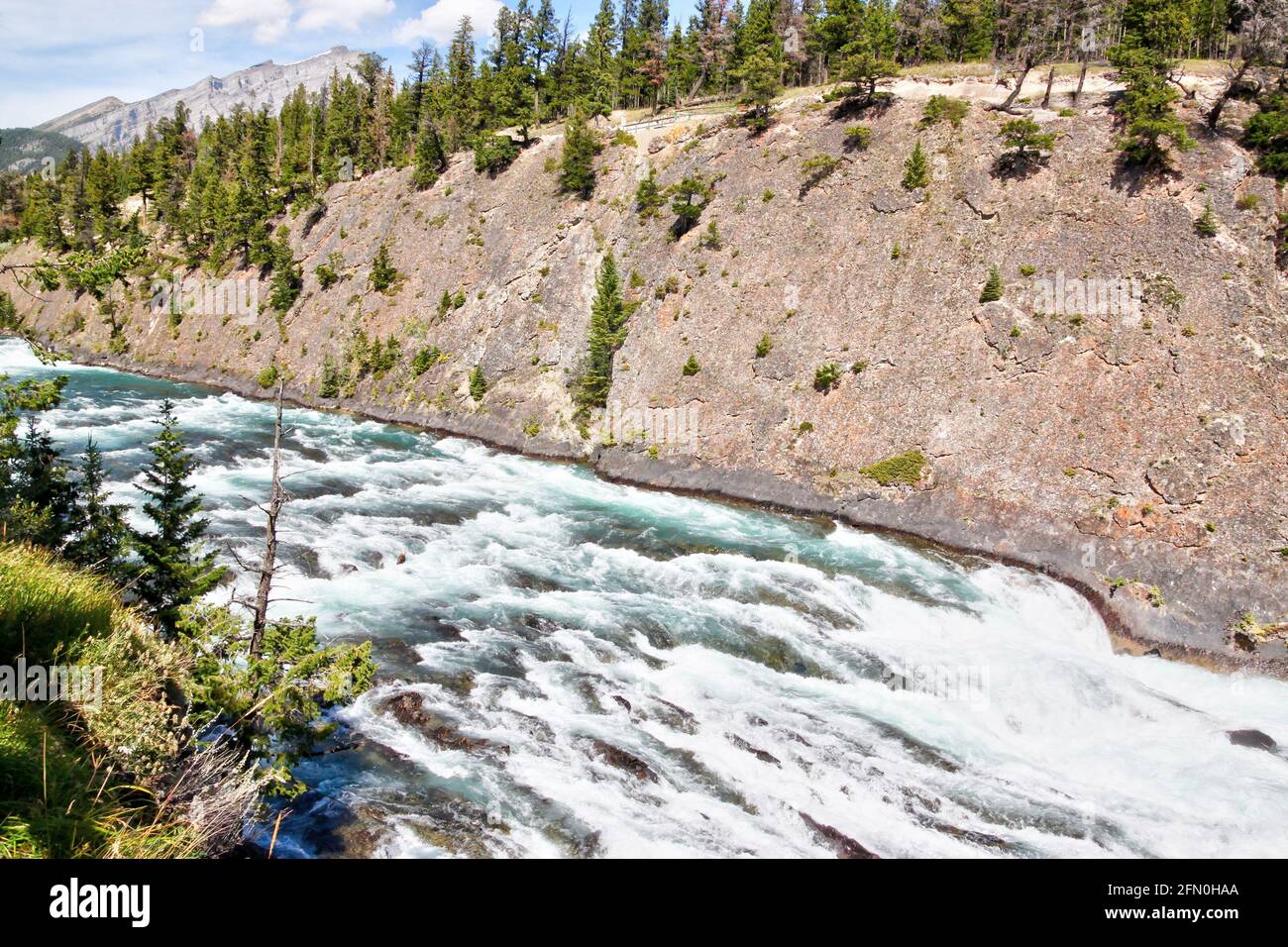 Roaring rapids along Bow Falls trail flowing toward Bow Falls, a major