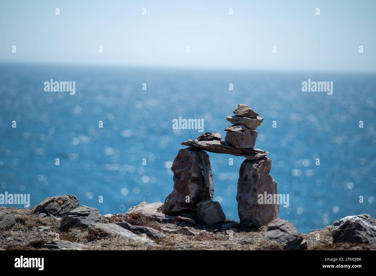 Inukshuk, a stack of granite rocks in the form of a person. The formation is a symbol of direction. The Inuit traditional figure is high on a hill. Stock Photo