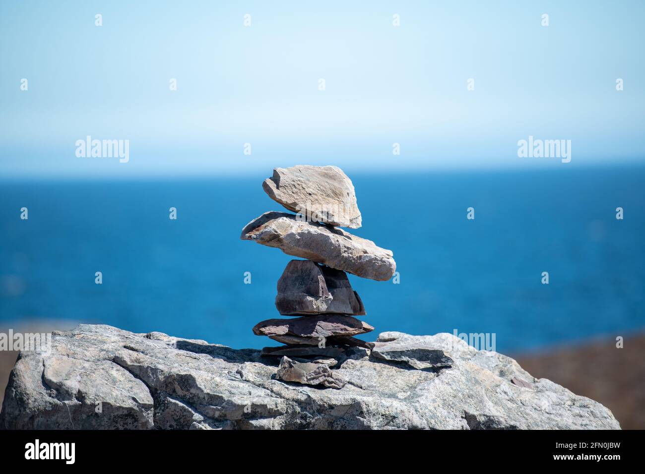 Inukshuk, a stack of granite rocks in the form of a person. The formation is a symbol of direction. The Inuit traditional figure is high on a hill. Stock Photo