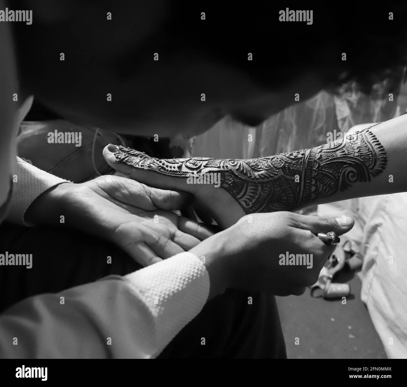 henna being applied to foot of an indian bride. Stock Photo