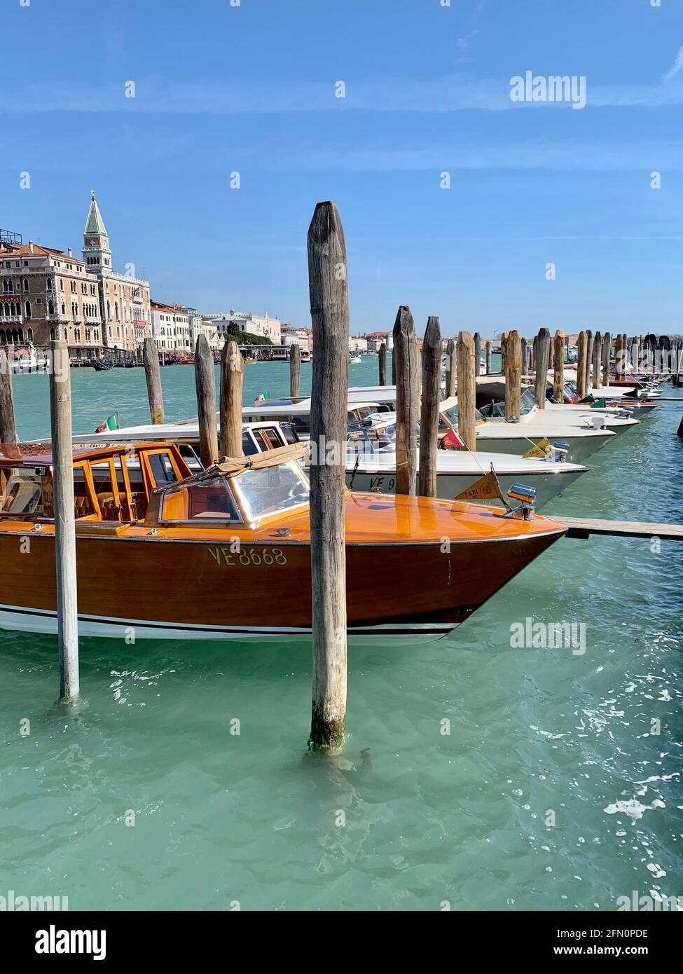 Beautiful Wooden Water Taxis Parked Among Mooring Poles In Venice Italy Stock Photo