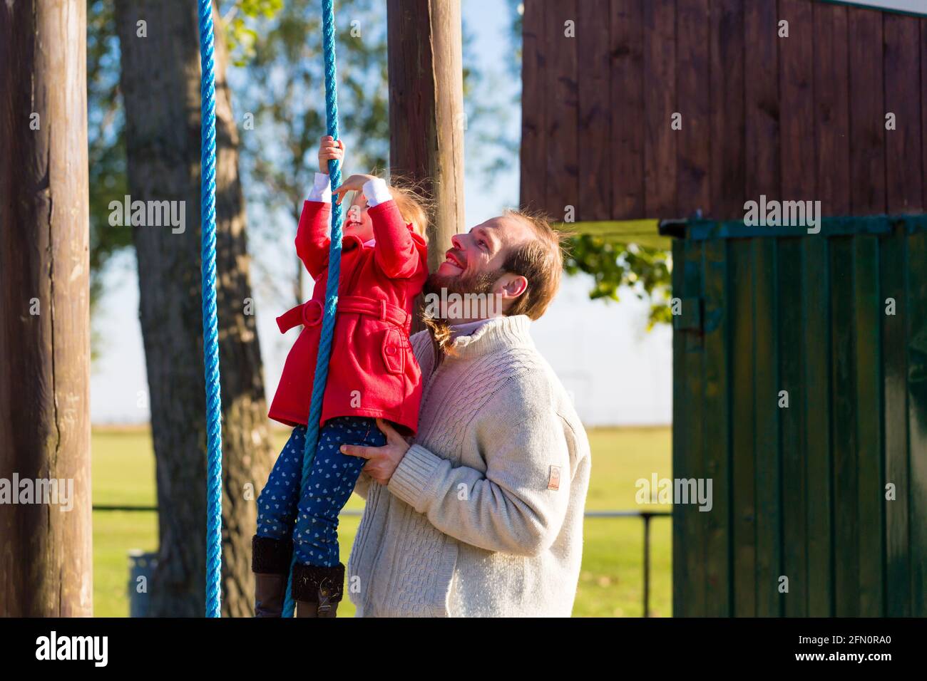 Family with Father and daughter climbing and playing on play area or court Stock Photo