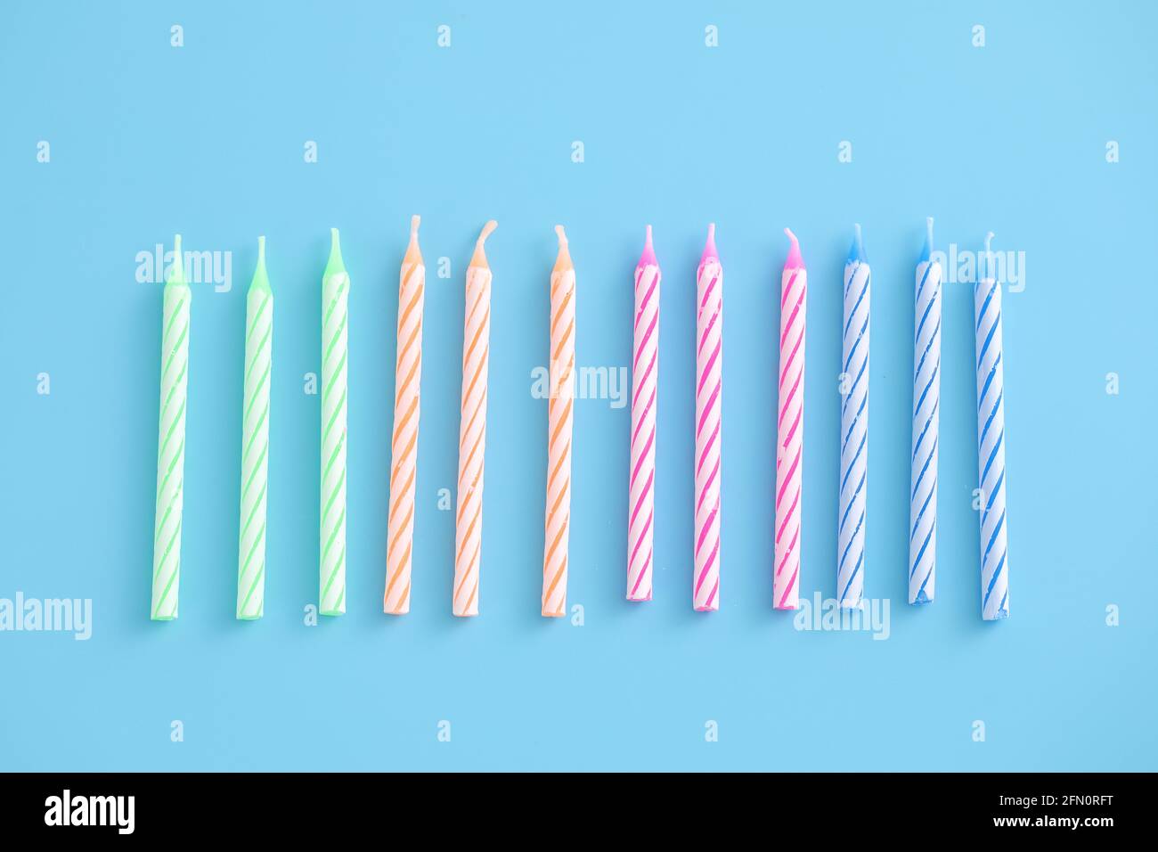 Colorful candles isolated in blue background Stock Photo - Alamy