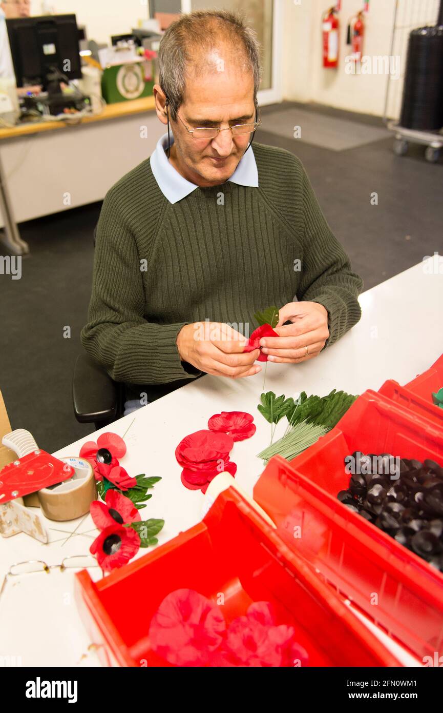 David Forbes making poppies at The Royal British Legion's Poppy Factory, 20 Petersham Road, Richmond, London, UK. The Poppy Factory employs ex-service personnel to makes poppies, remembrance crosses, sprays and wreaths for The Royal British Legion’s annual Appeal and Remembrance Day. The Poppy Factory is also responsible for planting and hosting The Field of Remembrance at Westminster Abbey. The Royal British Legion's Poppy Factory, 20 Petersham Road, London, UK.  16 Oct 2013 Stock Photo