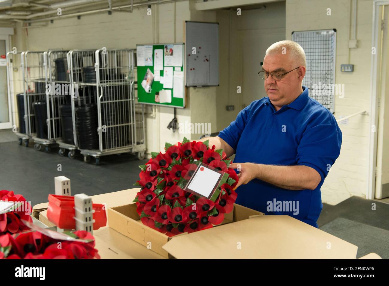 Paul Hammerton packing wreaths at, The Royal British Legion's Poppy Factory, 20 Petersham Road, Richmond, London, UK. The Poppy Factory employs ex-service personnel to makes poppies, remembrance crosses, sprays and wreaths for The Royal British Legion’s annual Appeal and Remembrance Day. The Poppy Factory is also responsible for planting and hosting The Field of Remembrance at Westminster Abbey. The Royal British Legion's Poppy Factory, 20 Petersham Road, London, UK.  16 Oct 2013 Stock Photo