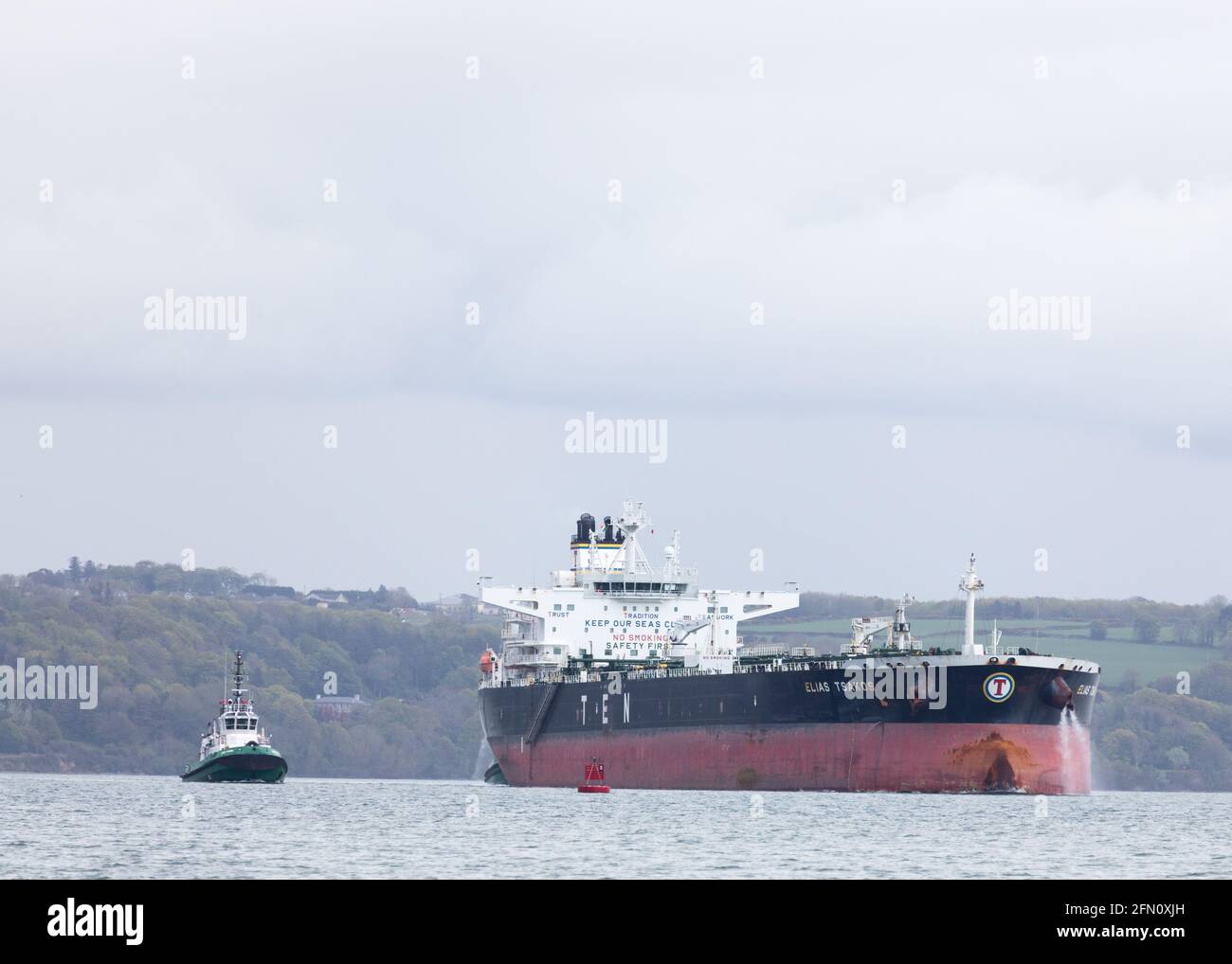 Whitegate, Cork, Ireland. 12th May, 2021. Oil tanker Elias Tsakos is assisted by tugboats Titan and Alex as she slowly manoeuvres away from the jetty and departs the harour on her way to Scapa Flow at Whitegate, Co. Cork, Ireland.  - Credit; David Creedon / Alamy Live News Stock Photo